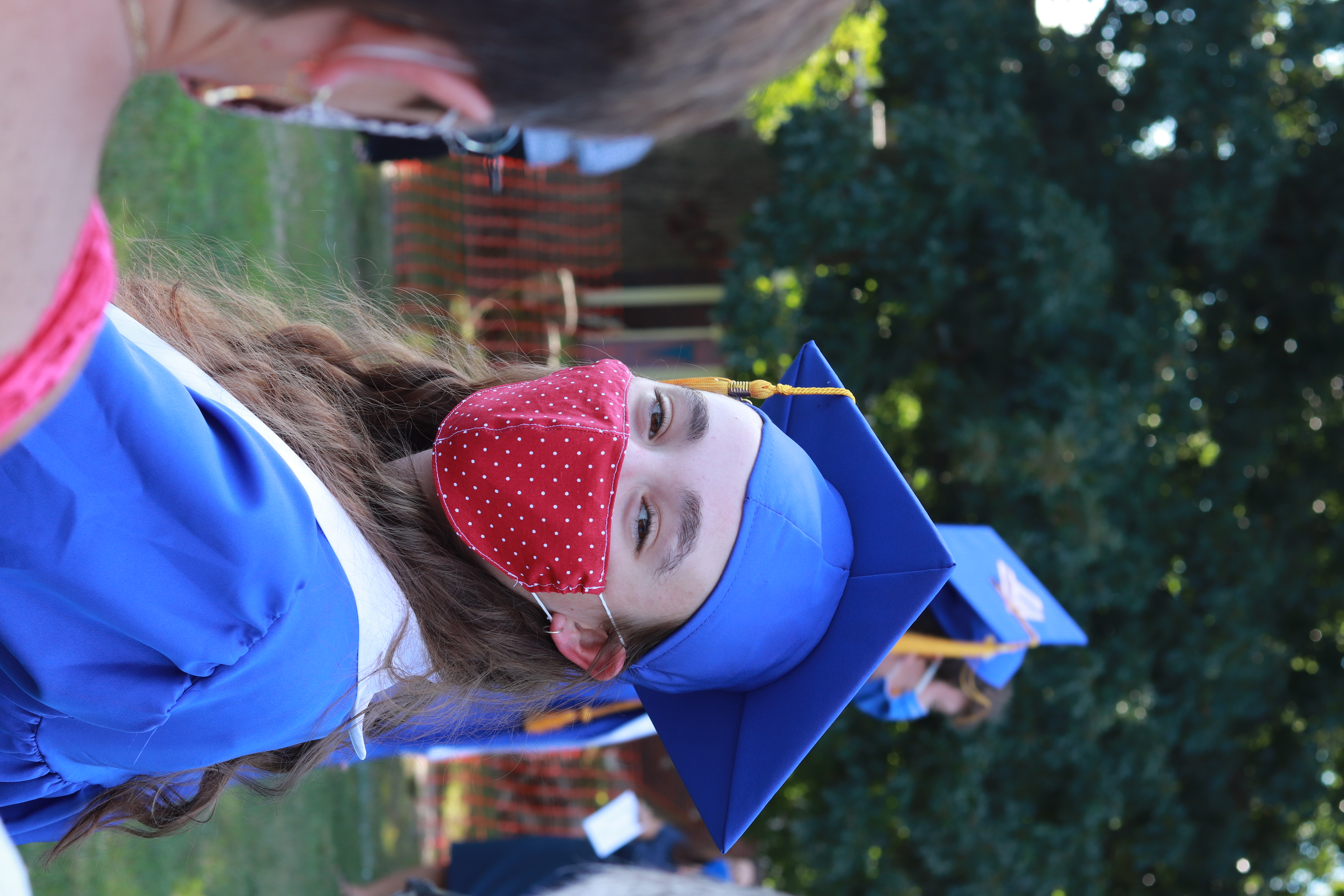 An outdoor high school graduation, extremely long hair courtesty of lockdown.